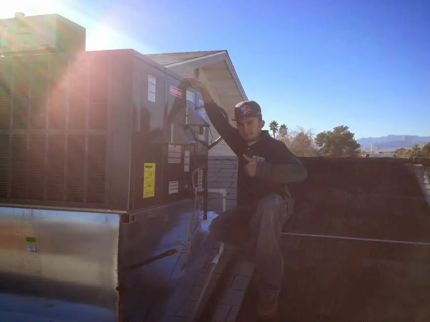 HVAC technician performing AC Tune-Up on a rooftop unit in Sikeston